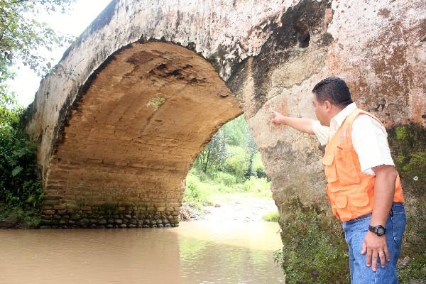 Carlos  Enrique Marroquín,  delegado  de la Conred, señala  el daño  en el puente Jocol, ubicado  en el kilómetro 174,   San Antonio Ilotenango, Quiché.