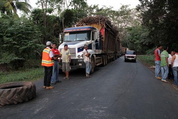 Vecinos bloquean el paso de camionos cañeros. (Foto Prensa Libre: Rolando Miranda)<br _mce_bogus="1"/>