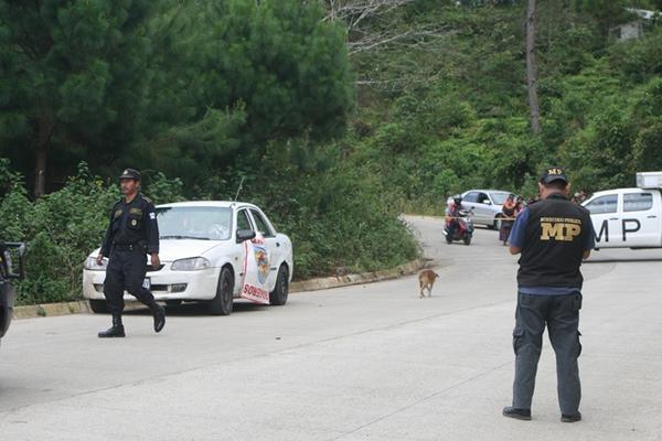 Autoridades resguardan el taxi en el que murió baleado Carlos Enrique Cucul, en Cobán. (Foto Prensa Libre: Ángel Tax)