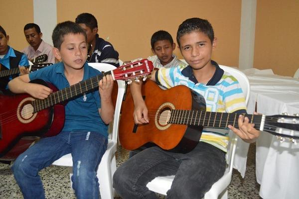 Un grupo de estudiantes ejecuta guitarras acústicas en la clausura de la primera promoción de la Escuela Municipal de Bellas Artes de Teculután. (Foto Prensa Libre: Víctor Gómez) <br _mce_bogus="1"/>