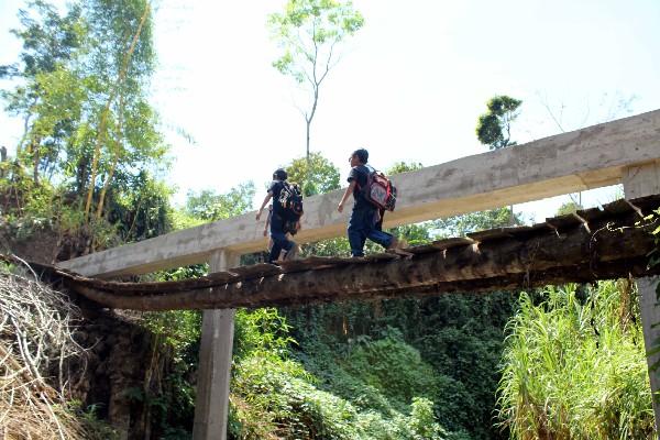 A diario, decenas de niños se arriesgan   al cruza   un puente de madera que fue construido por vecinos del cantón Acosito, San Sebastián, Retalhuleu.