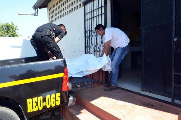 El cuerpo de la víctima es trasladado en un vehículo de la Policía Nacional Civil (Foto Prensa Libre: ROLANDO MIRANDA).