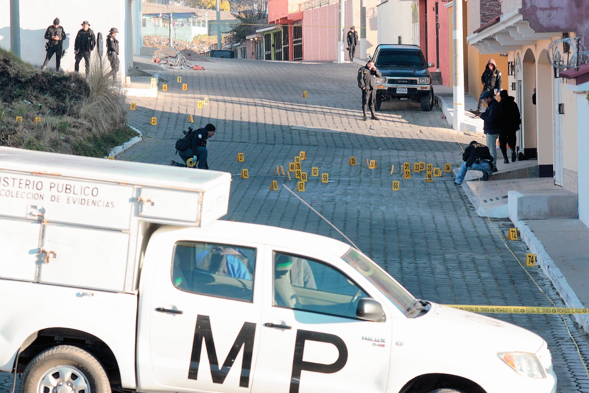 Investigadores de la PNC y fiscales del Ministerio Público recogen evidencias afuera de una vivienda atacada en Quetzaltenango. (Foto Prensa Libre: Carlos Ventura)