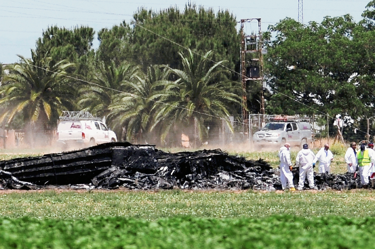 Expertos inpecionan los restos del Airbus A400M se estrelló cerca del aeropuerto de Sevilla. (Foto Prensa Libre: AFP).