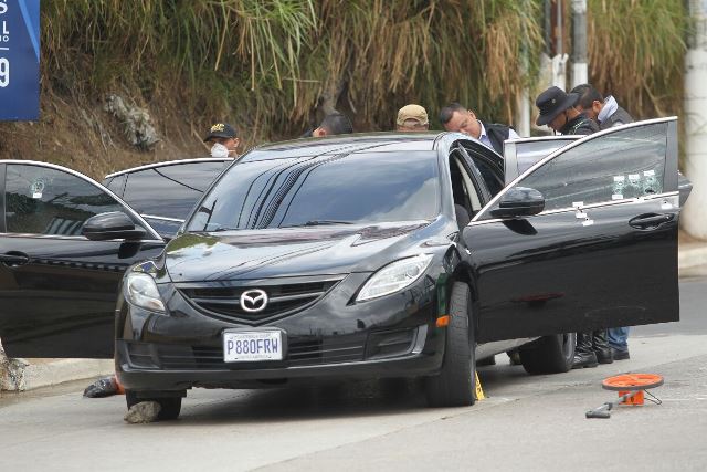 Fiscales del MP e investigadores policiales revisan vehículo en el que viajaban las víctimas. (Foto Prensa Libre: Erick Ávila)