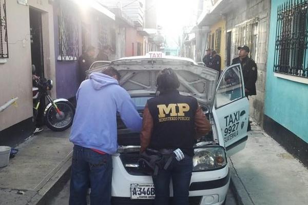 Un agente fiscal y un investigador de la Policía verifican los datos de un taxi durante los operativos de hoy (Foto Prensa Libre: PNC)