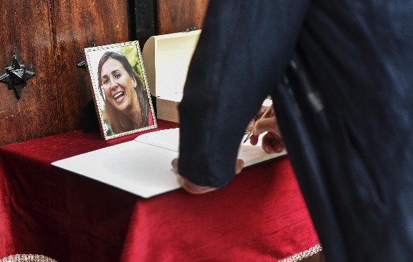 Un hombre firma en el libro de condolencias durante el funeral de María Villar. (Foto Prensa Libre: EFE)