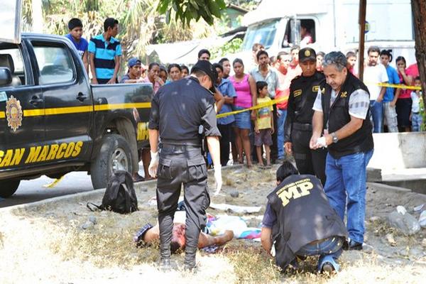 Autoridades y vecinos obseervan el cadáver de German Waldemar Rabanales Sánchez, en Tecún Umán, San Marcos. (Foto Prensa Libre: Alexánder Coyoy)