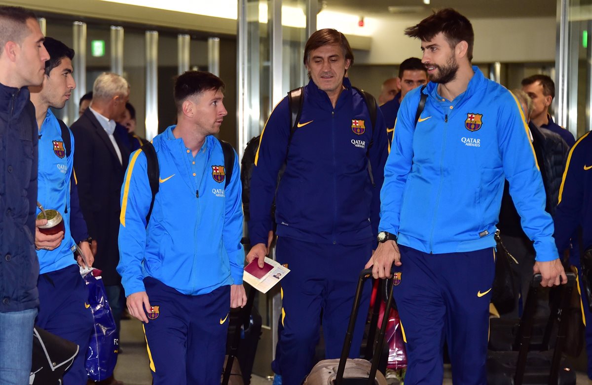 Lionel Messi y Piqué a su llegada a Tokio, donde el Barsa jugará el Mundial de Clubes. (Foto Prensa Libre: AFP)