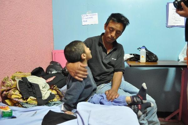 El niño,  junto  a su padre,  en  la sala de Pediatría  del Hospital  Regional de Huehuetenango.