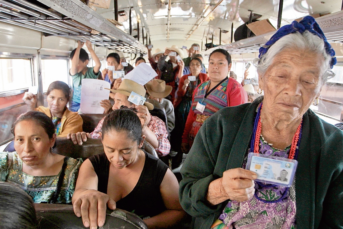 Pobladores de San Andrés Itzapa, Chimaltenango, muestran su DPI al llegar, en autobuses, al TSE, con la intención de ratificar su afiliación al PLP.