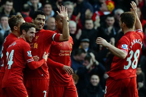 El uruguayo Luis Suárez —de frente— celebra  uno de los dos goles que consiguió ayer en el triunfo del Liverpool ante Cardiff. (Foto Prensa Libre: AFP)