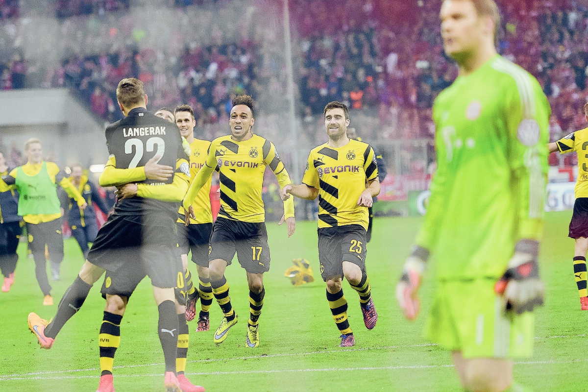 El portero del Borussia Dortmund Mitchell Langerak es abrazado por sus compañeros de equipo, ante la desazón del cancerbero del Múnich, Manuel Neuer. (Foto Prensa Libre: AFP)