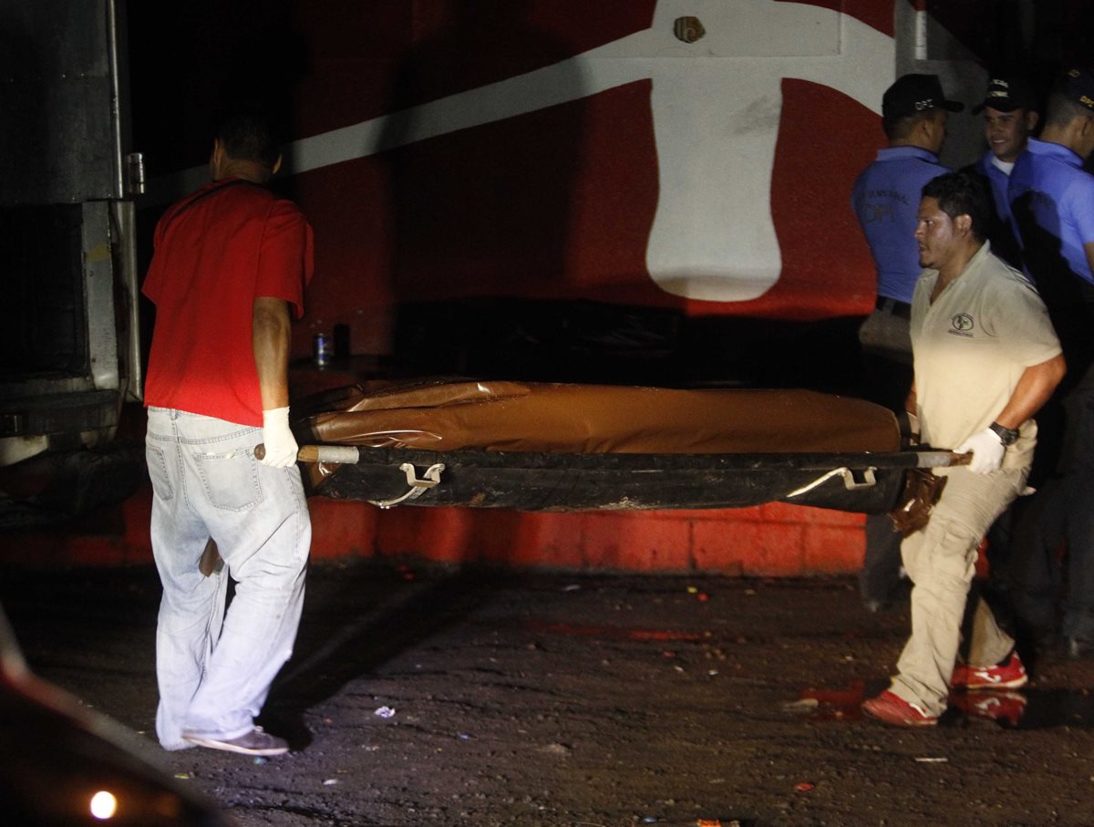 Fiscales y socorristas trasladan el cuerpo de una victima de una balacera en Honduras. Ese país registra un promedio de 13 muertes diarias por violencia. (Foto Prensa Libre: AP).