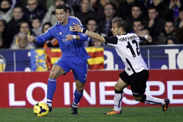 Cristiano Ronaldo  conduce el balón ante la marca de  Joao Pereira, del Valencia. (Foto Prensa Libre: AP)