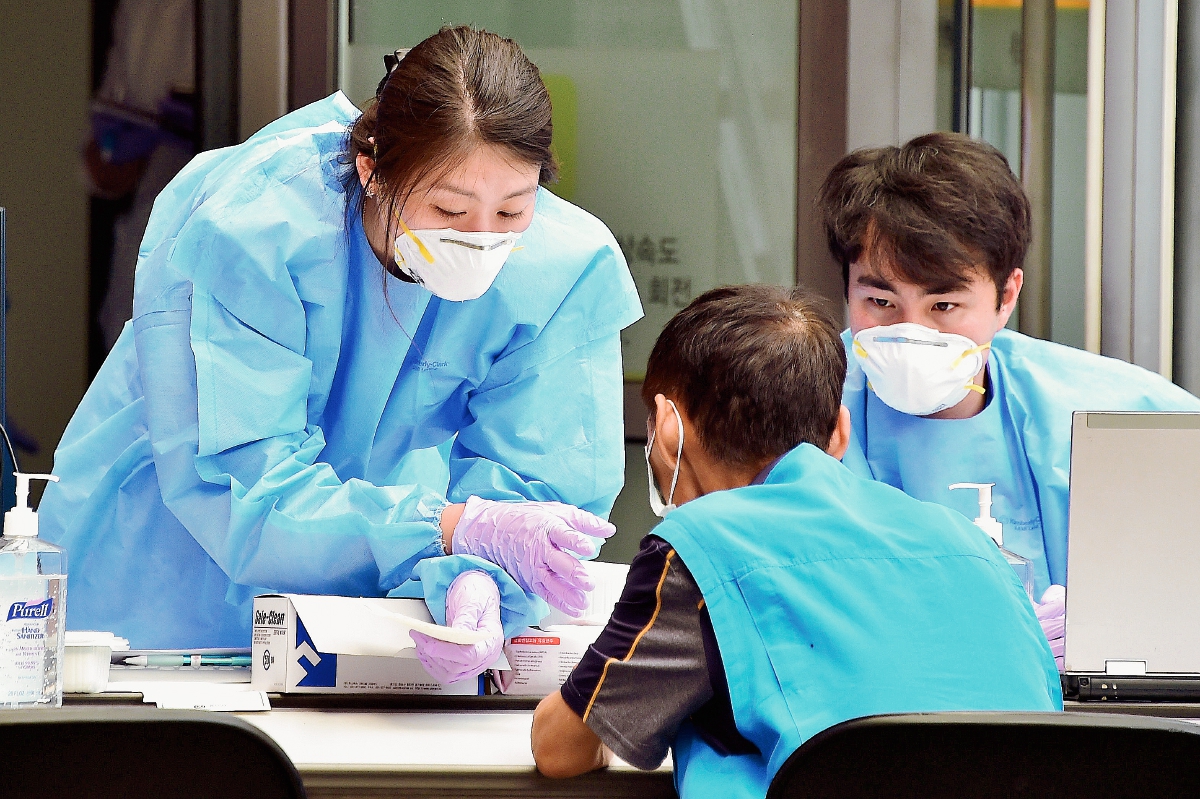 Trabajadores de la salud atienden a un paciente con problemas respiratorios. (Foto Prensa Libre:AFP).AFP