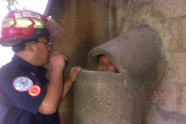 Un bombero rompe el drenaje para resctar al muchacho. (Foto Prensa Libre: Bomberos Municipales)<br _mce_bogus="1"/>