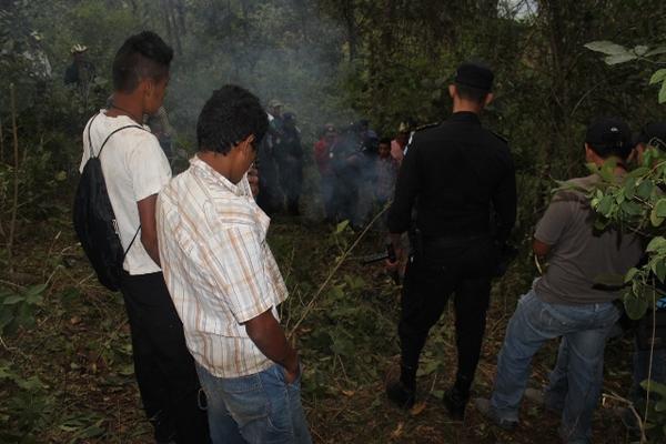 Vecinos y agentes de PNC permanecen cerca de los restos de uno de los hombres que fue linchado y quemado. (Foto Prensa Libre: Oscar González)<br _mce_bogus="1"/>