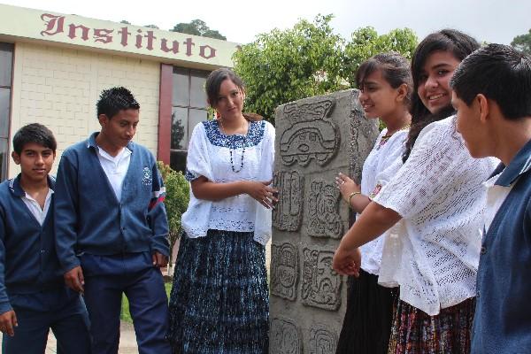 Jóvenes del Instituto Normal Mixto del Norte de Cobán, Alta Verapaz, muestran una estela.
