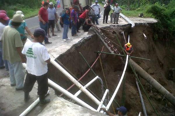 Vecinos reparan parte de la tubería que quebró el hundimiento ocurrido en el kilómetro 189 de la ruta entre Retalhuleu y Xela. (Foto Prensa Libre: Rolando Miranda)<br _mce_bogus="1"/>