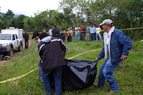 Agentes del Ministerio Público cargan el cuerpo de José David Ibáñez Ortiz, en El Duraznal, Mataquescuintla, Jalapa.