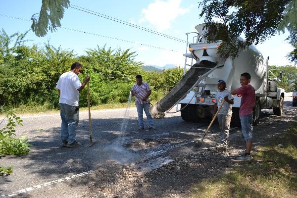 vECINOS REllenan baches en un  tramo entre Zacapa y Chiquimula.