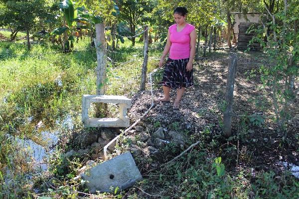 Vecina  del  barrio  San Juan,  de San Benito, muestra la caja  de registro de donde   desconocidos robaron  el medidor  de agua.