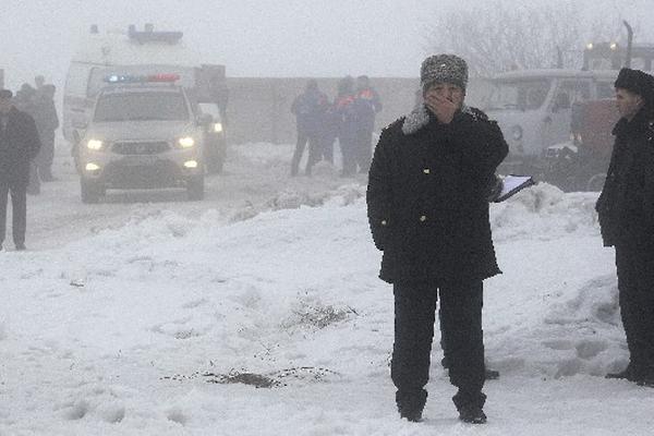 Autoridades inspeccionan lugar donde ocurrió accidente aéreo, en  Alma Ata, Kazajistán. (Foto Prensa Libre: EFE)