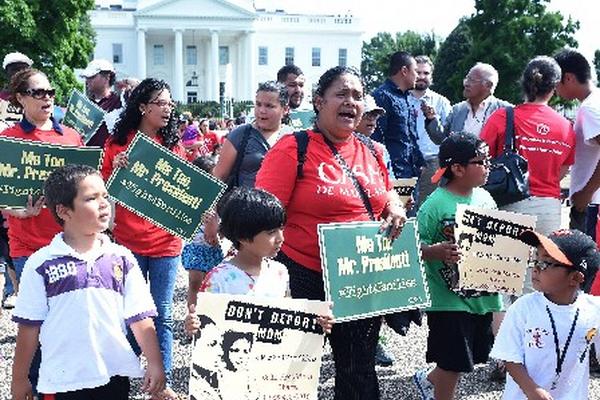 Inmigrantes indocumentados sostienen pancartas en contra de la deportación. (Foto Prensa Libre: EFE)