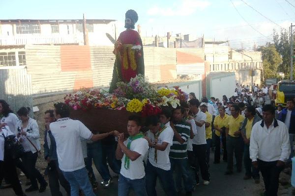 Vecinos  llevan en hombros   la imagen  de San Marcos Evangelista, en la cabecera.