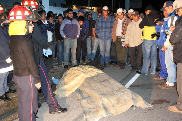 Curiosos observan el cadáver de Claudino Gaspar Toc, quien murió baleado, en Sololá. (Foto Prensa Libre: Ángel Julajuj)