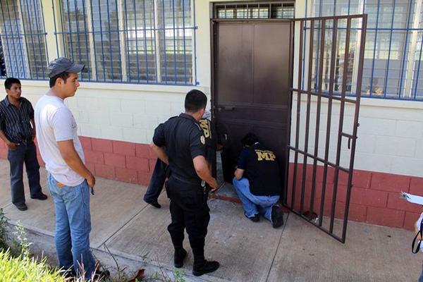 Trabajadores del Ministerio Público y agentes de la PNC revisan el ingreso al aula virtual de la escuela saqueada. (Foto Prensa Libre: Rolando Miranda)<br _mce_bogus="1"/>