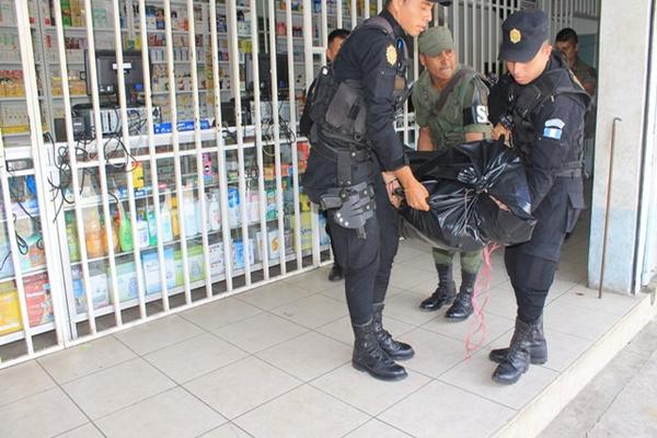 Agentes de la PNC y soldado trasladan el cuerpo de una de las víctimas de intoxicación. (Foto Prensa Libre: Enrique Paredes)<br _mce_bogus="1"/>