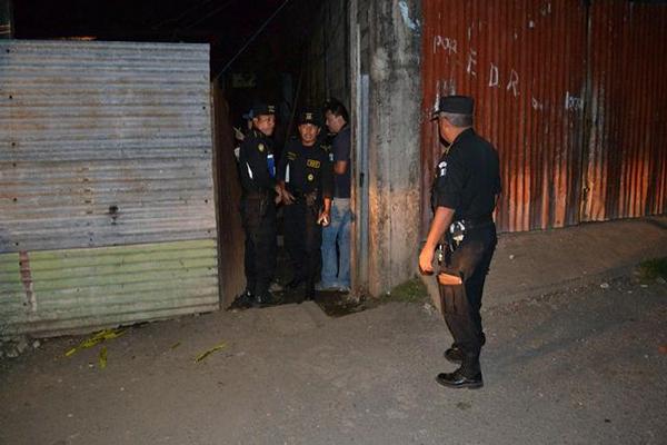 Agentes de la PNC permanecen en la entrada de la vivienda donde fue ultimado Odwal Ulises Grijalva, en Santa Lucía Cotzumalguapa. (Foto Prensa Libre: Enrique Paredes)