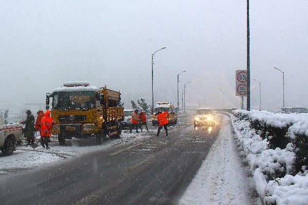 Trabajadores riegan sal sobre una carretera en Hangzhou, provincia de Zhejiang,China. (Prensa Libre: AFP)