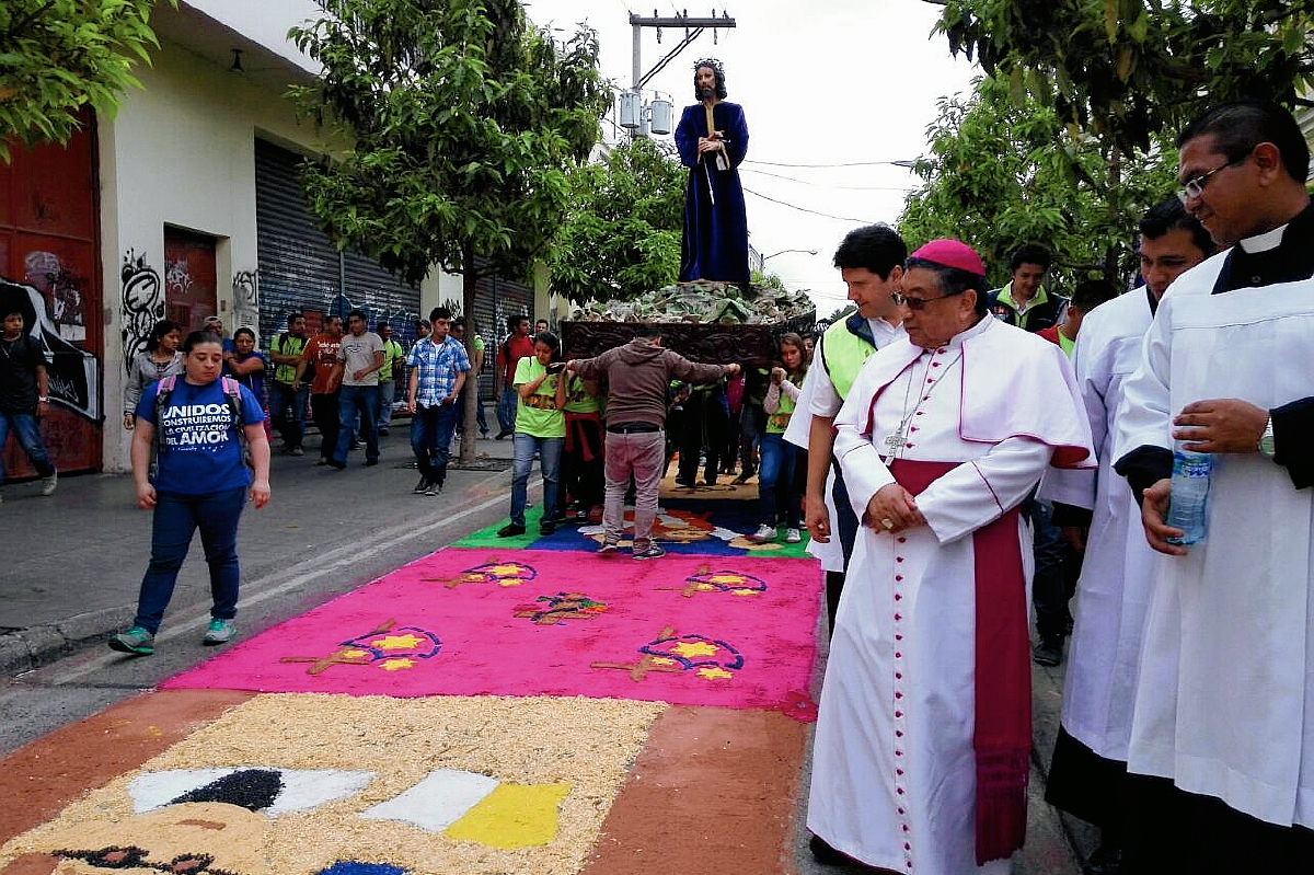 Moseñor Óscar Julio Vian Morales, observa la alfombra del Paseo de la Sexta, durante el paso de la procesión de la imagen del Cristo Cautivo. (Foto Prensa Libre: Edwin Bercián).