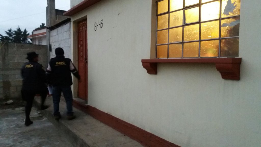 Agentes de la PNC entran en una de las viviendas allanadas en varios puntos de Quetzaltenango. (Foto Prensa Libre: PNC)
