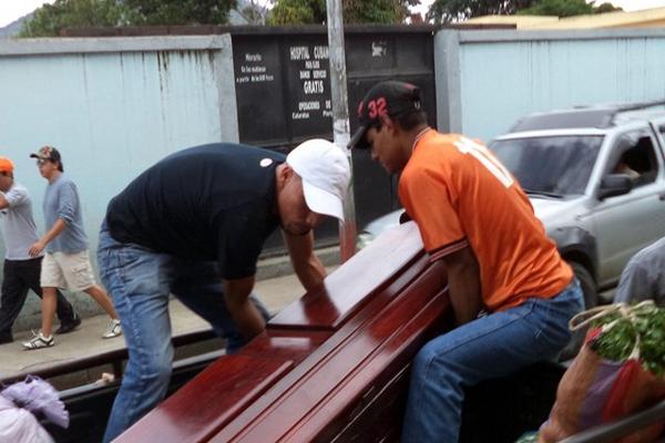 Empleados de una funeraria trasladan el cadáver de Erick Zacarías Elías Jiménez, quien murió tras un ataque armado en la aldea Talpetate. (Foto Prensa Libre: Hugo Oliva)