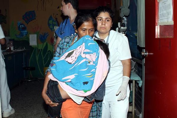 Una mujer ingresa a su hijo al hospital. (Foto Prensa Libre: Rolando Miranda)<br _mce_bogus="1"/>