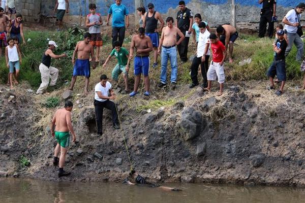 Socorristas rescatan de un río el cadáver de un hombre no identificado, el cual fue localizado por personas que se bañaban en ese afluente. (Foto Prensa Libre: Rolando Miranda)