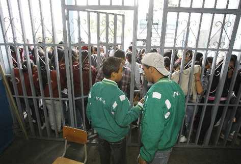 dos estudiantes mantienen cerrada  la puerta del Instituto Normal para Señoritas Centroamérica, el que se negaron a entregar ayer, como se habían comprometido.