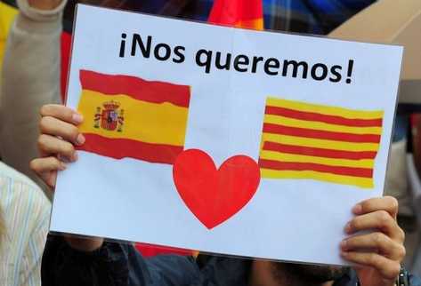 Manifestante antiindependentista muestra un cartel con las banderas española y catalana con un corazón. (Foto Prensa Libre: AFP)