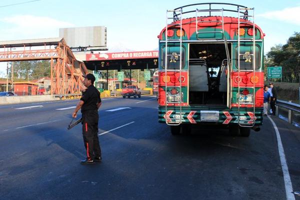 Guardias privados custodian el autobús asaltado. (Foto Prensa Libre: Carlos Paredes)<br _mce_bogus="1"/>