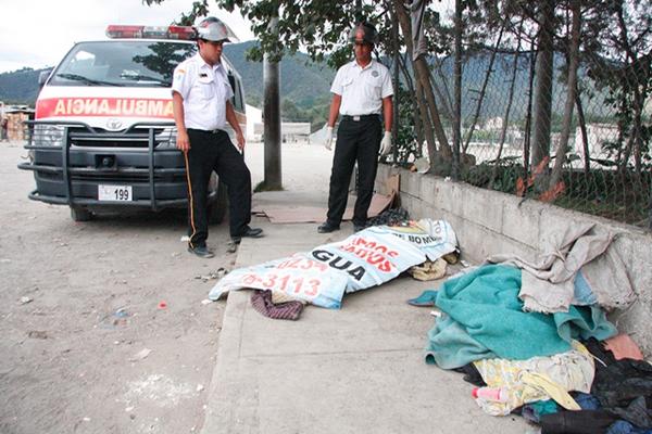 Socorristas a un lado del cadáver de hombre, a la espera de peritos del Ministerio Público. (Foto Prensa Libre: MiguelLópez)<br _mce_bogus="1"/>