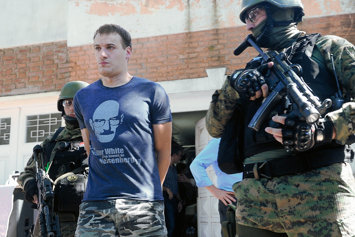 Policías argentinos llevan a uno de los detenidos que fabricaban éxtasis. (Foto Prensa Libre: AFP)