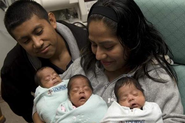 Rosa y Melvin contemplan a sus tres hijos en el hospital. (Foto: tomada de CourierPostOnline)