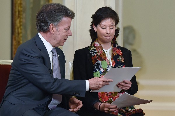  Juan Manuel Santos (iz) entrega copia de la ley a Natalia Ponce, víctima de ataque con ácido. (Foto Prensa Libre:AFP).