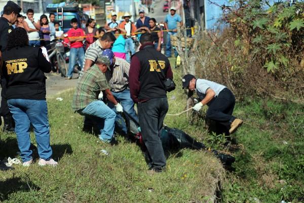 Voluntarios ayudan a sacar el  cuerpo.