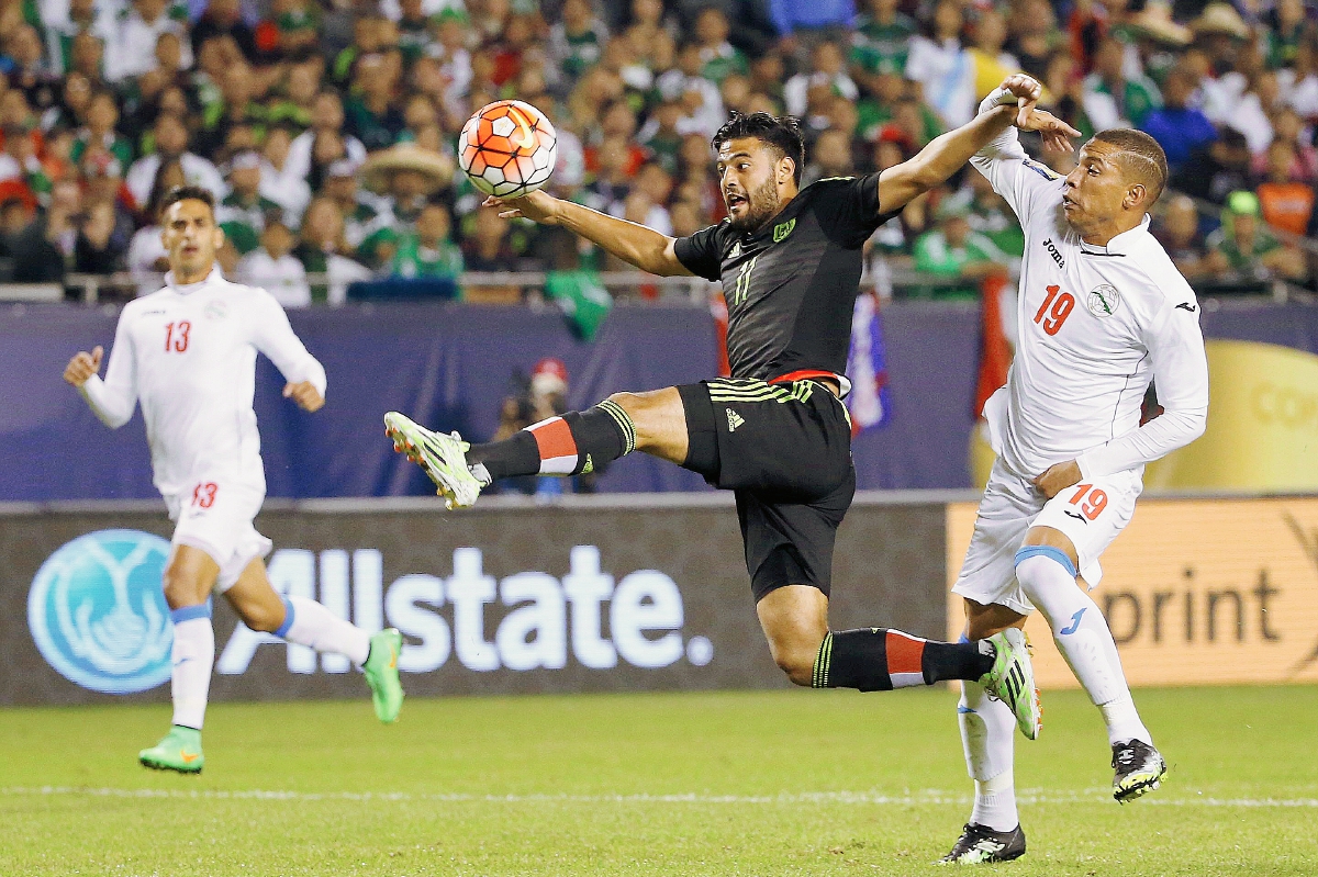 Carlos Vela (c) de México ante Yasmany López (d) de Cuba, en el juego disputado en el Soldier Field de Chicago, Illinois. (Foto Prensa Libre: EFE)