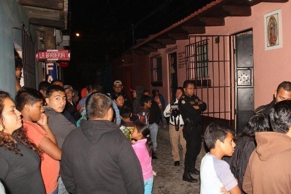 Curiosos permanecen frente a la vivienda donde fue encontrado el cadáver de Telma Argentina Vela, en Antigua Guatemala. (Foto Prensa Libre: Miguel López)